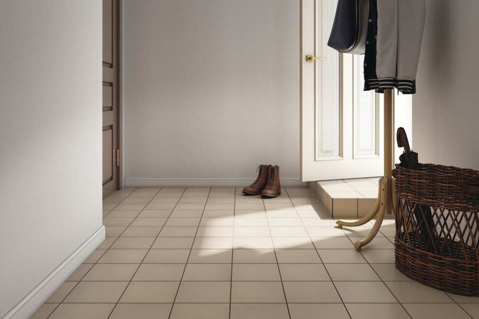 square quarry tile in neutral toned entryway with coat rack and wicker basket